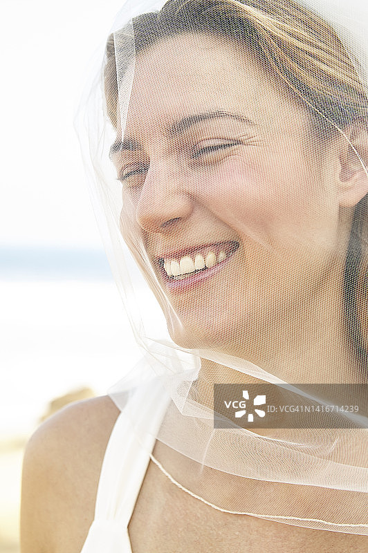 脸上蒙着面纱的快乐新娘图片素材