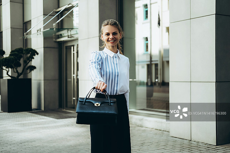 年轻女人户外挥舞手袋图片素材