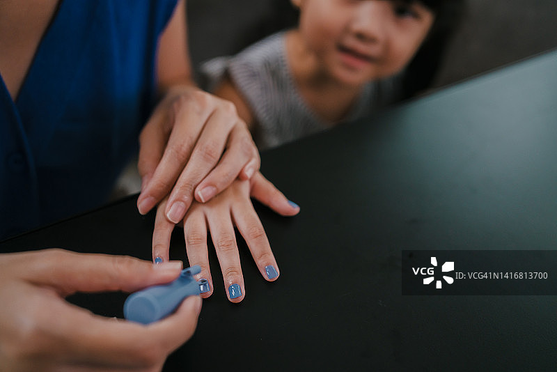 母亲和女儿在客厅用玩具指甲油涂指甲特写图片素材