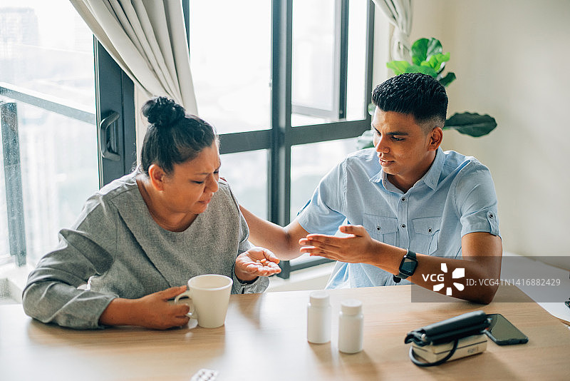 亚洲印度裔儿子请母亲吃药图片素材
