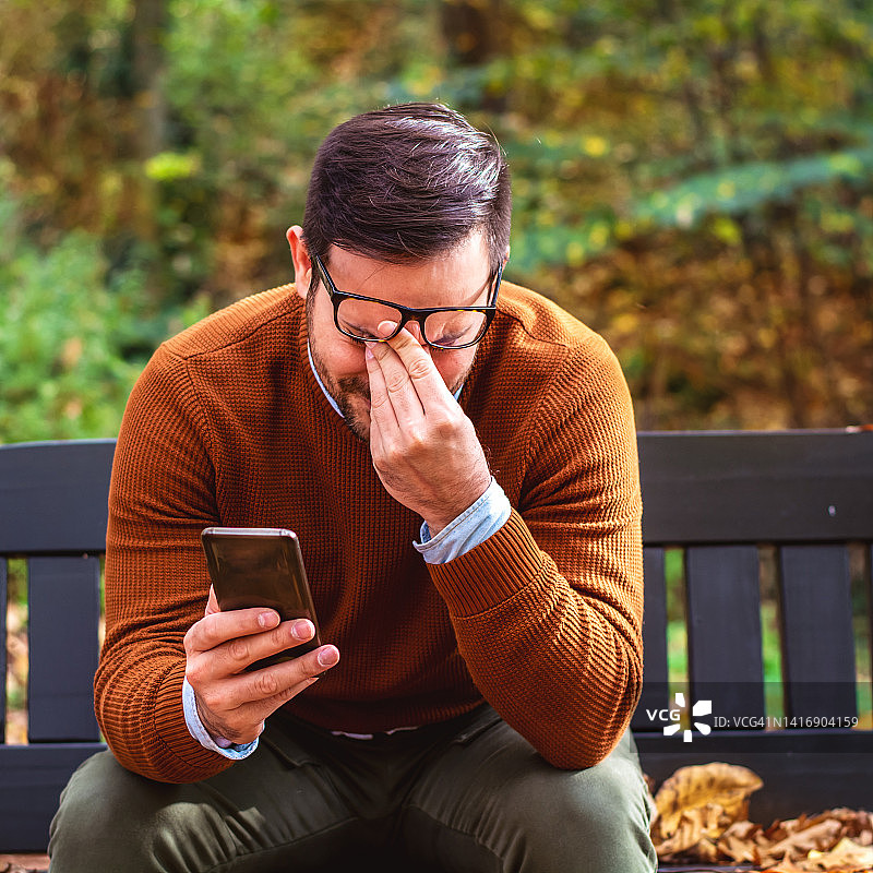 忧心忡忡的男人在使用手机图片素材