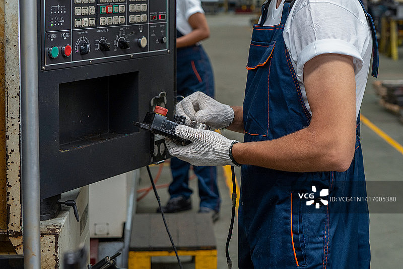 员工在制造工厂使用控制面板操作自动机器图片素材