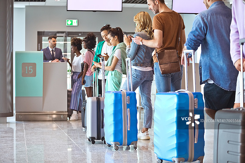 携带行李排队等候的旅客图片素材