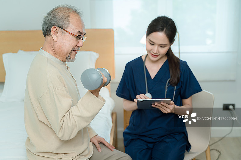 医生或护士与老年男性在家中或疗养院进行锻炼图片素材