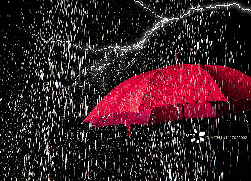 红色雨伞上的倾盆大雨和闪电图片素材