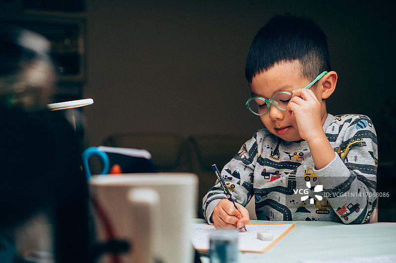 晚上做作业的5岁中国男孩图片素材