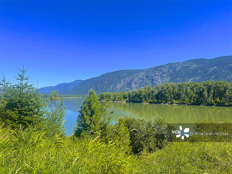 小堡附近的茂盛树叶、河流和山脉图片素材