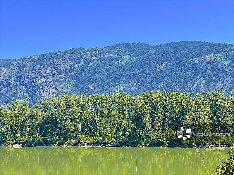 小堡附近的茂盛树叶、河流和山脉图片素材