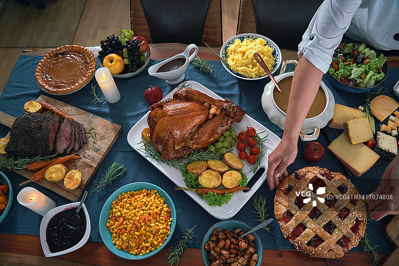 感恩节烤牛肉和酿火鸡与汤、蔬菜、南瓜和浆果派以及其他食材图片素材