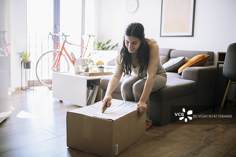 年轻女子在家打开一个盒子图片素材