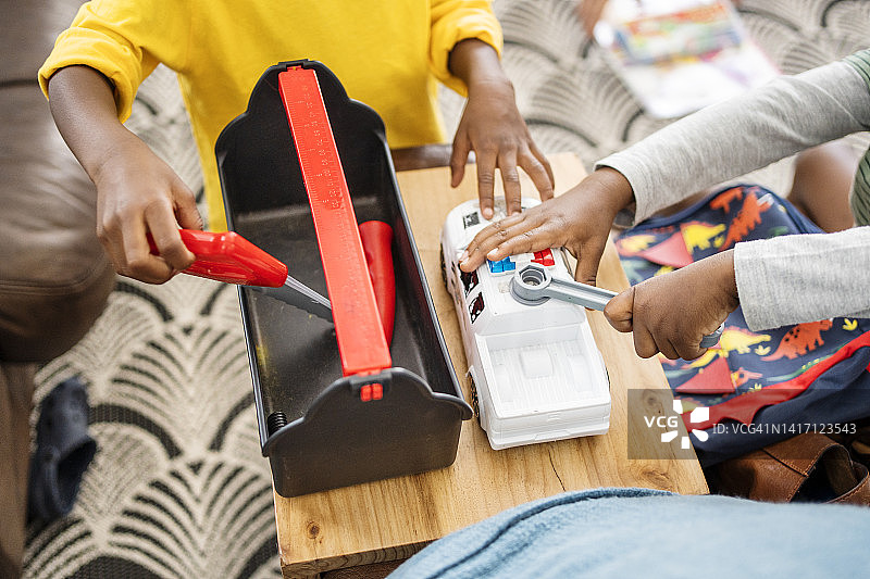 可爱的小男孩们在家一起玩玩具工具图片素材