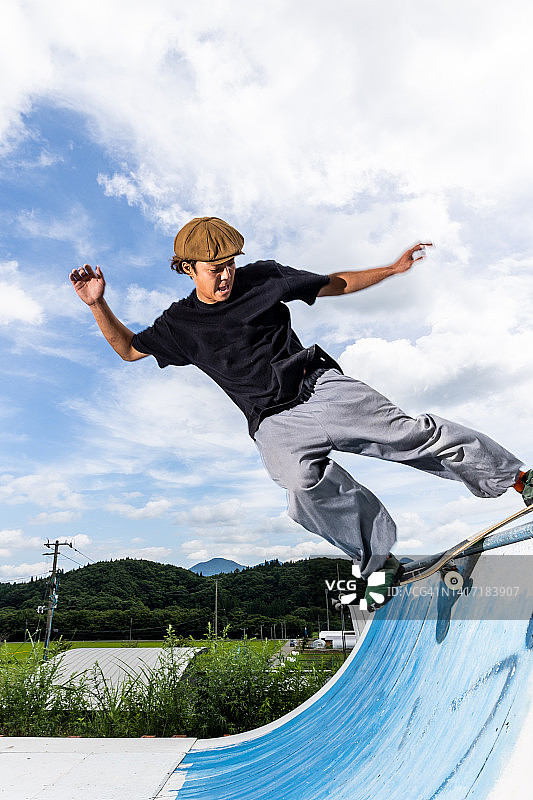 滑板运动员在半管上做技巧图片素材