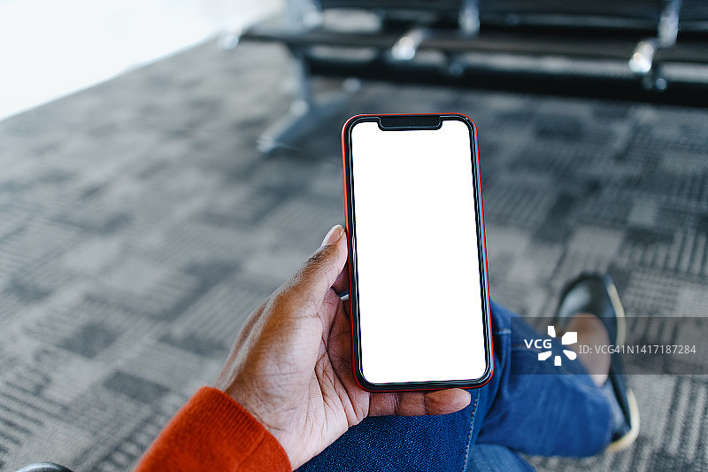 女人坐在机场候机区使用智能手机图片素材