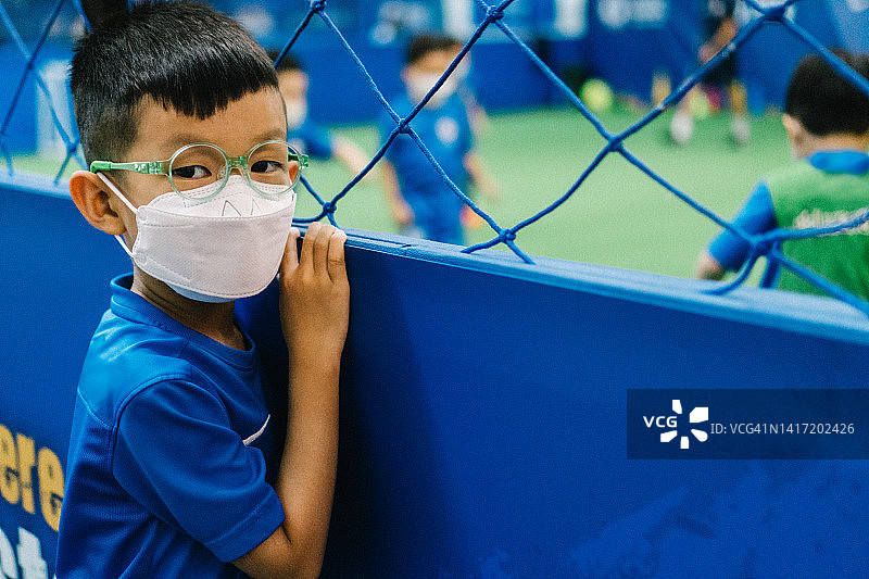 在香港戴着口罩等待足球比赛的儿童图片素材