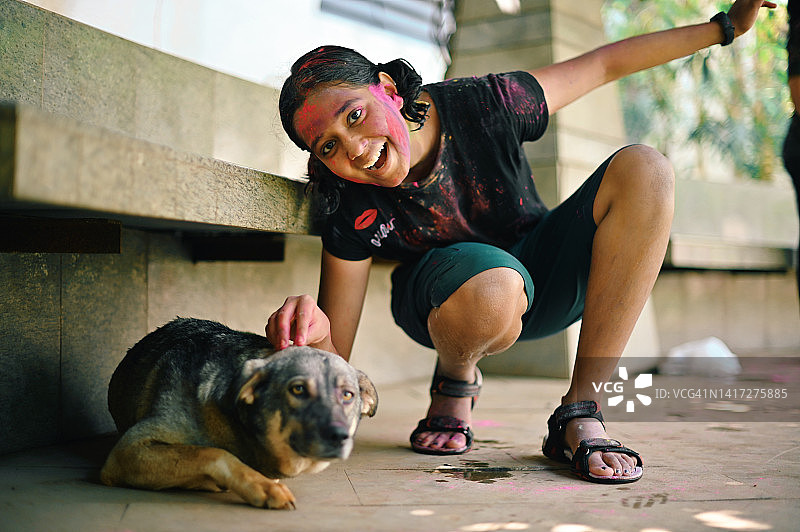 和狗玩耍的彩绘脸少女图片素材