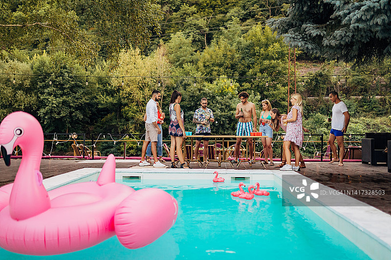 一小群人在泳池边玩啤酒乒乓球图片素材