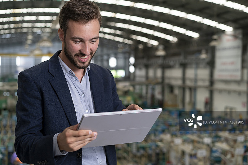 在工厂使用平板电脑的商人图片素材