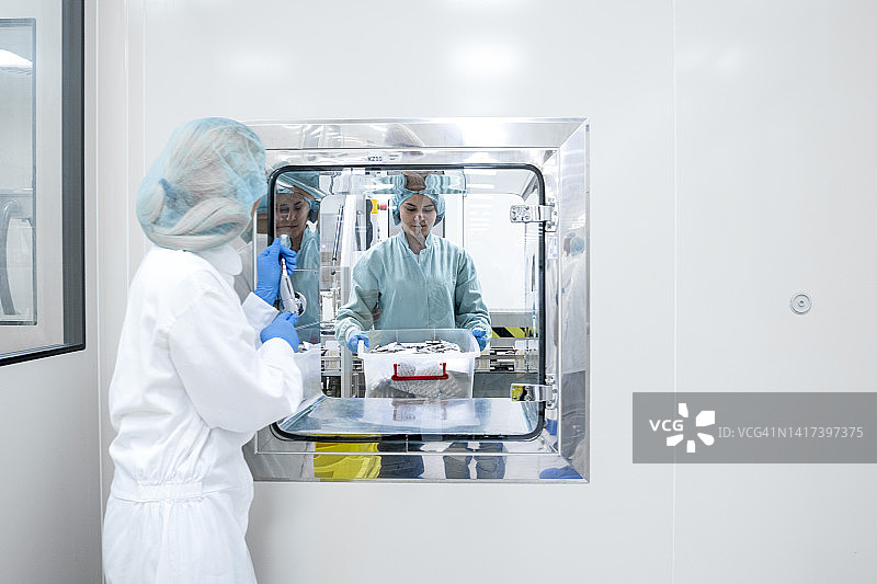 制药厂的女人们正在交接泡罩包装盒图片素材