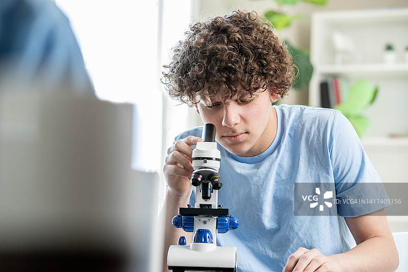 高中生在科学课上用显微镜观察图片素材