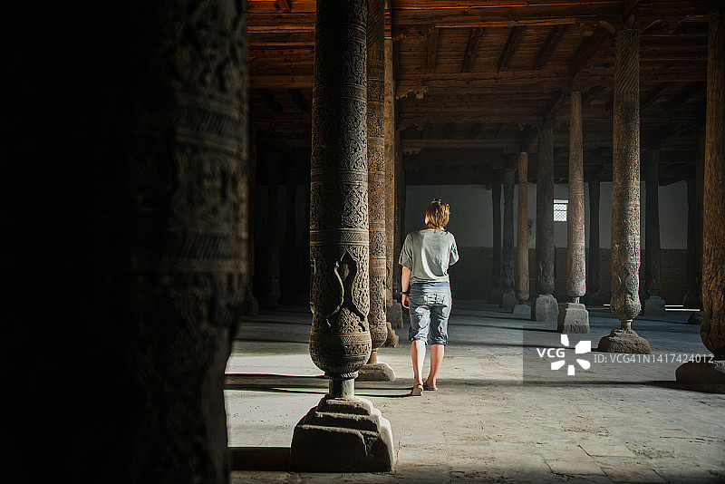 沿着希瓦伊钦卡拉朱玛清真寺的木柱行走的沃兰，乌兹别克斯坦图片素材