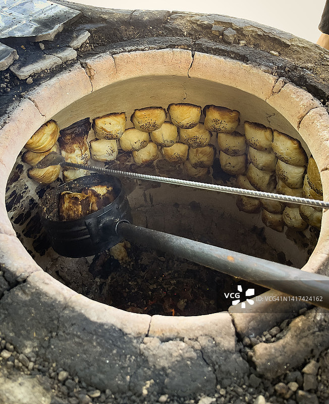 在塔什干，乌兹别克斯坦的早餐期间，馕坑烤炉中烤制的萨姆萨肉馅饼图片素材