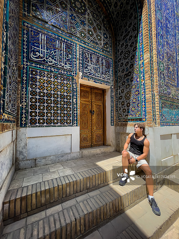 游客在撒马尔罕夏伊辛达伊斯兰建筑群纪念馆阴凉处休息，乌兹别克斯坦图片素材