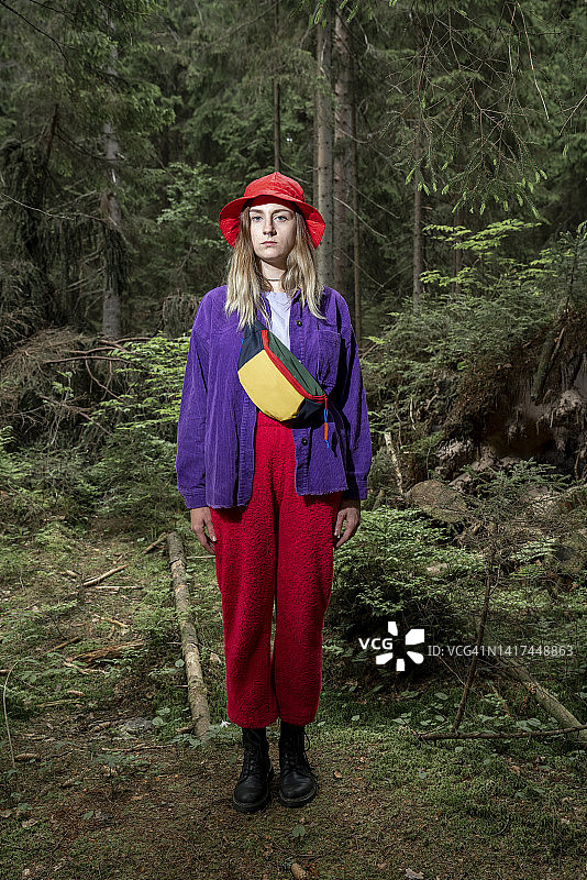 戴着渔夫帽站在森林里的女人图片素材