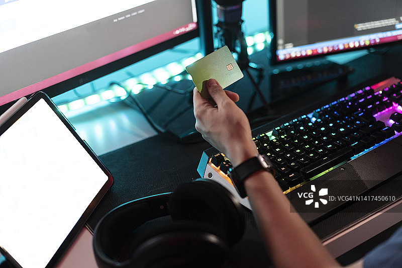 男人在家中电脑前手持信用卡图片素材