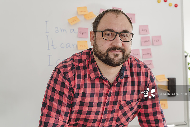 戴眼镜的老师在家中白板前图片素材