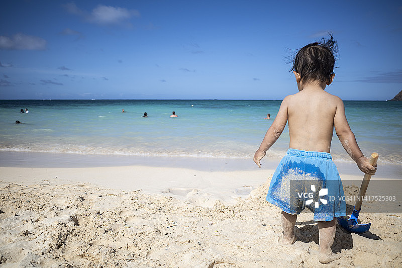 在夏威夷海滩玩沙子的小男孩图片素材