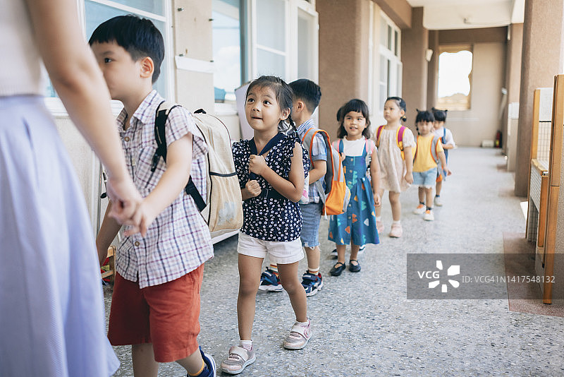 学龄前教师指导和安排排队等候进入教室的学生图片素材