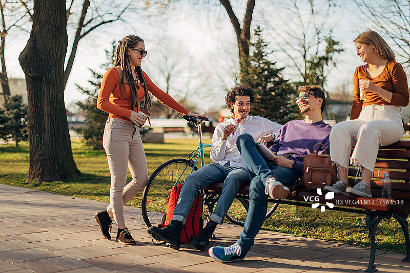 坐在公园长椅上闲逛的年轻人图片素材