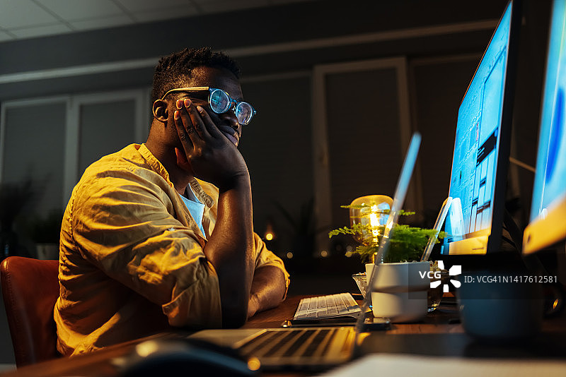 办公室里无聊的男性程序员在电脑上工作图片素材