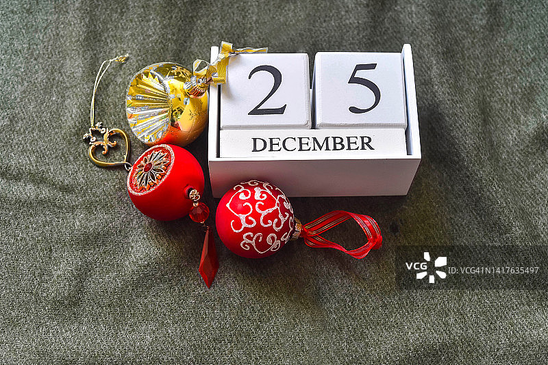 圣诞装饰品、木制日历块（数字25和12月）与绿色桌布图片素材