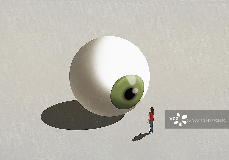 站在大型绿色眼球前的女人图片素材