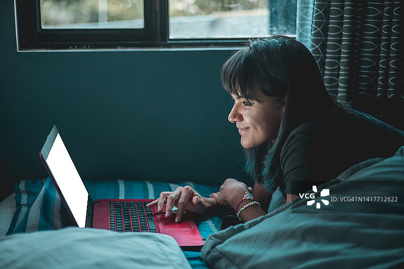 在床上使用电脑的女人图片素材