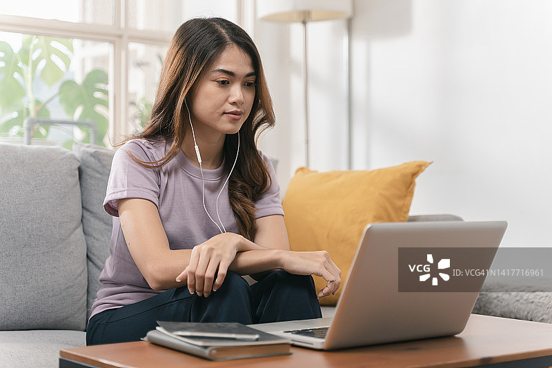 在家学习的年轻亚洲女性看笔记本电脑图片素材