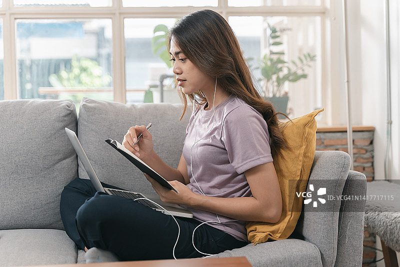 在家学习的年轻亚洲女性看笔记本电脑图片素材