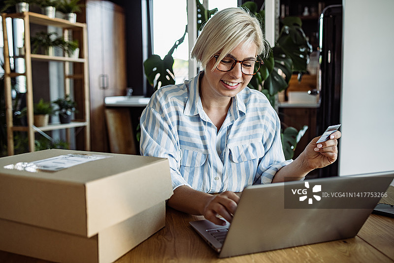 年轻女人用信用卡进行网上购物图片素材