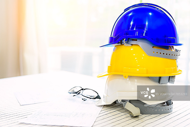 桌子上的眼镜、头盔、卷尺和蓝图图片素材