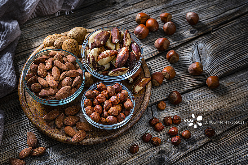 黑桌上的榛子、杏仁和巴西坚果图片素材