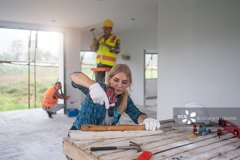 女木匠在木工车间用手钻组装木材图片素材