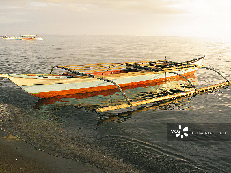 菲律宾吕宋岛黎牙实比市：停泊在黄昏海中的螃蟹船图片素材