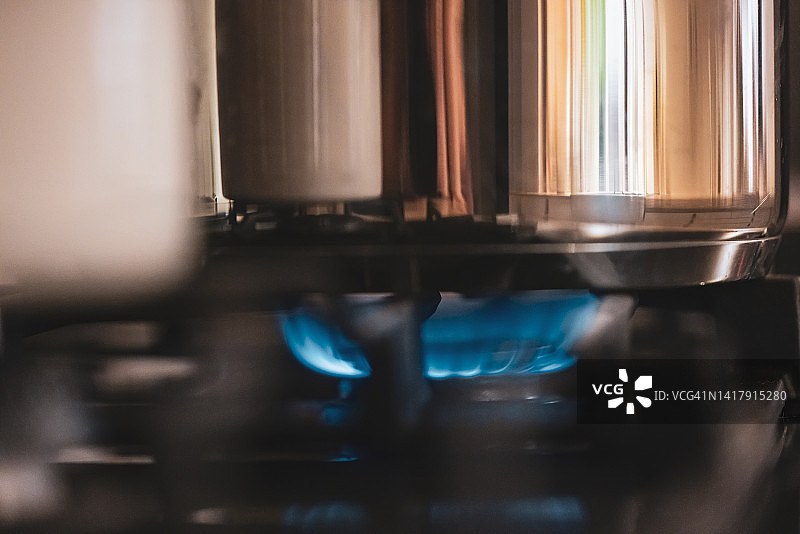 燃气灶蓝色火焰上的锅特写图片素材