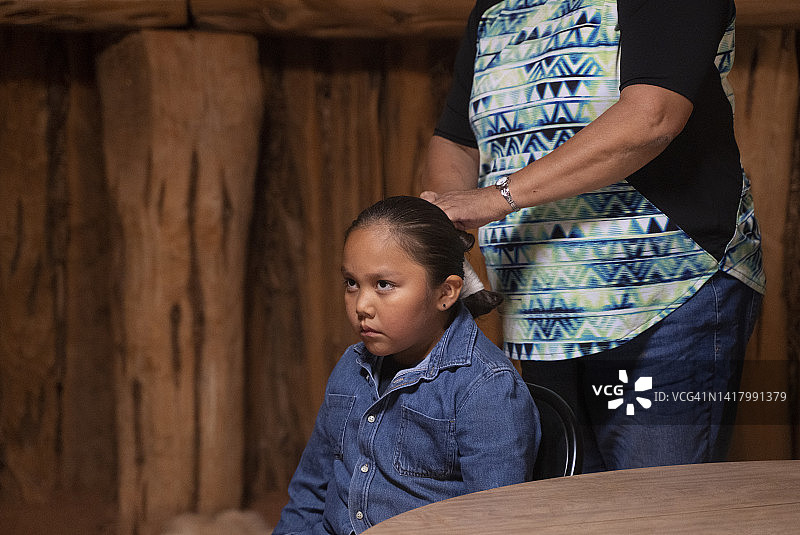 纳瓦霍族妇女以传统方式为儿子梳头图片素材