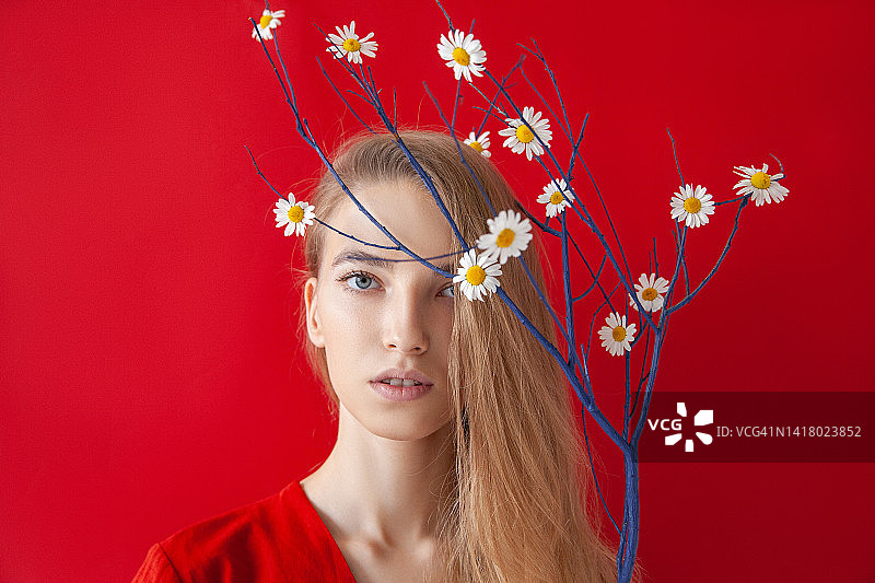 年轻女人手持带花的枯枝图片素材