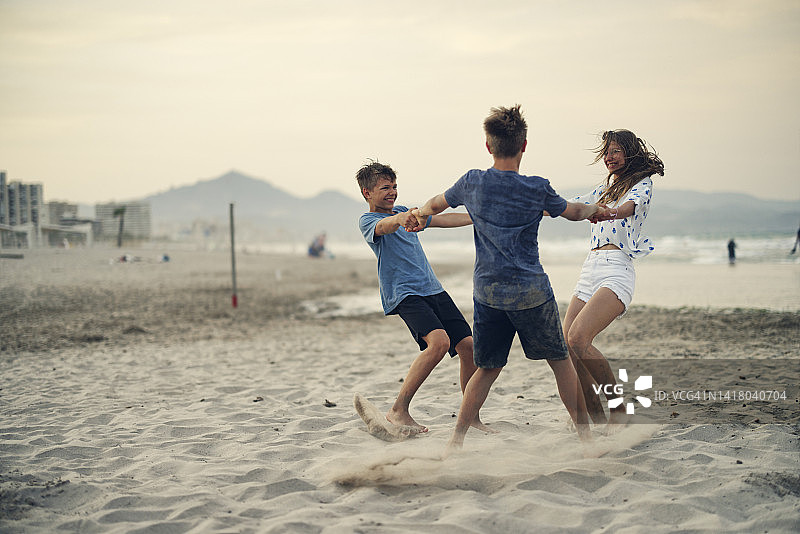 三个青少年在傍晚享受阿利坎特海滩图片素材