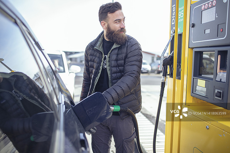 络腮胡男人给油箱加油图片素材