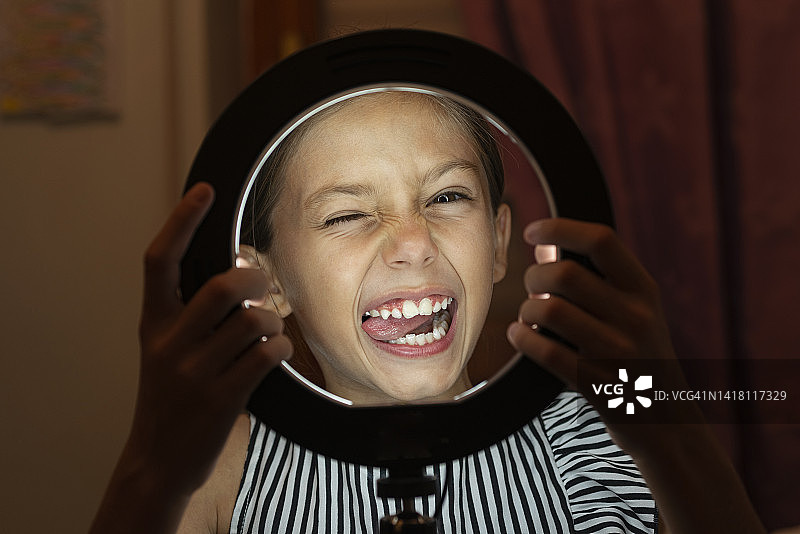 快乐的青少年用环形灯做鬼脸图片素材