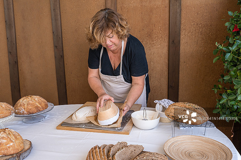 女子将面包从烤盘中取出图片素材